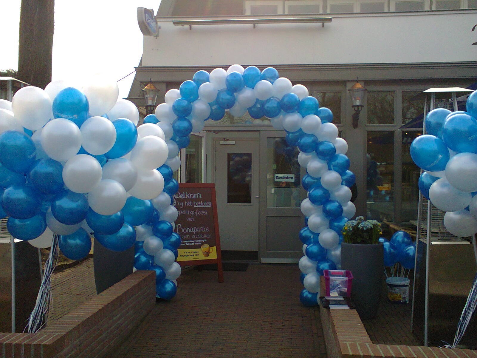 helium ballonnen en ballonnenboog opening restaurant met bedrukte ballonnen